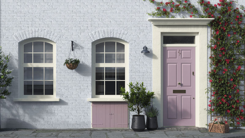 A terraced cottage with beautifully painted masonry and contrasting front door 